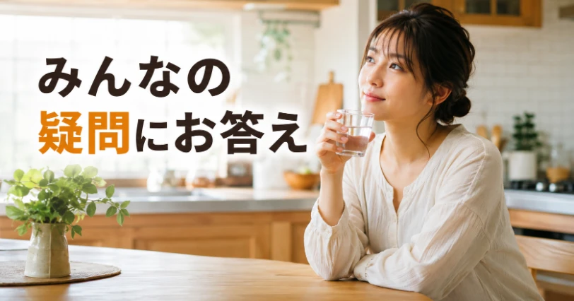 コップの水を手にして疑問を考える人物を写した、よくある質問をイメージした写真