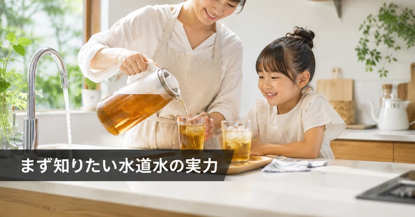 明るいキッチンで母親が水道水でいれた麦茶をグラスに注ぎ、子どもが笑顔で待っている場面のイメージ